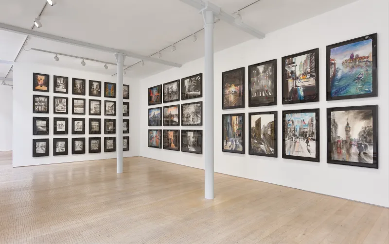 Gallery view with smaller monochrome works alongside larger colourful cityscapes