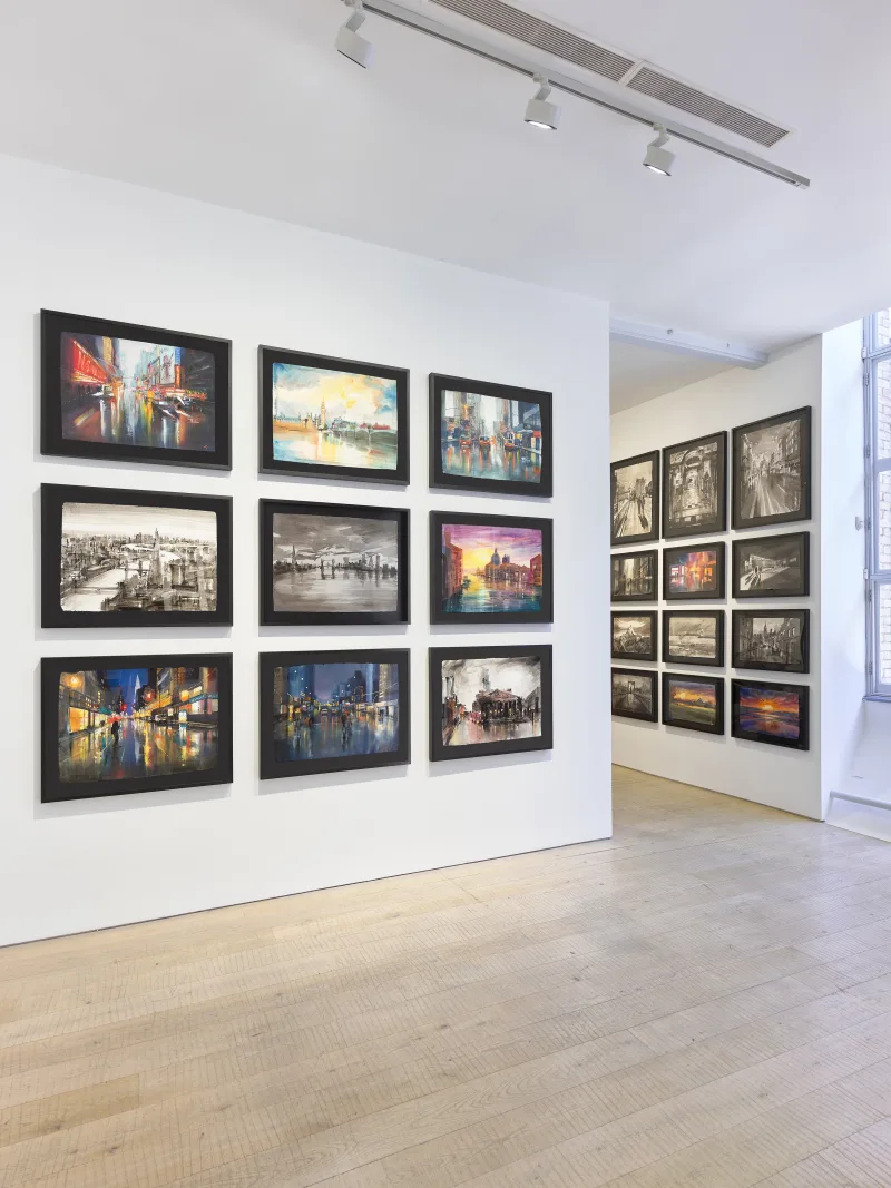 Gallery corner with colourful cityscapes and monochrome studies on artisan paper